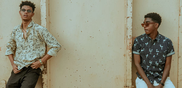 Portrait of young man standing against wall