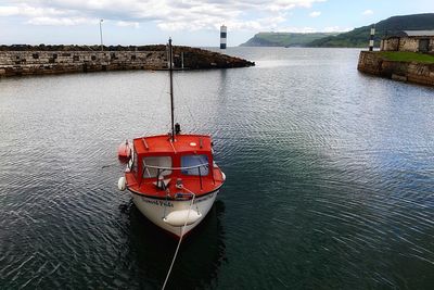 Red boat on sea against sky