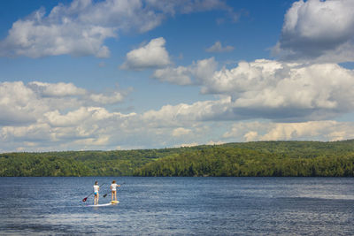 Men in water against sky