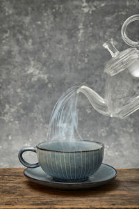 Abstract close up of tea cup and teapot pouring steam