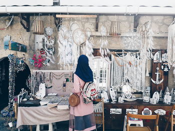 Rear view of woman standing at store