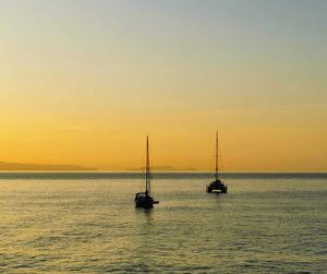 Sailboat sailing on sea against sky during sunset