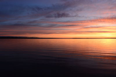 Scenic view of sea against dramatic sky during sunset