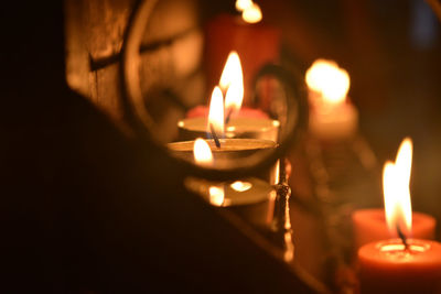 Close-up of lit candle in the dark