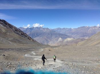 People on mountain against sky