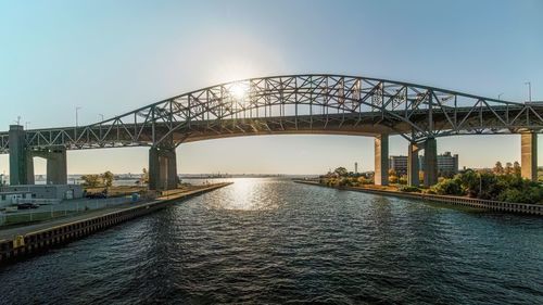 Bridge over river against sky during sunset