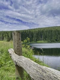 Wooden fence on field against sky