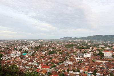 High angle view of crowded bandar lampung city against cloudy sky