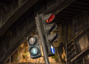 Low angle view of stoplight against abandoned building