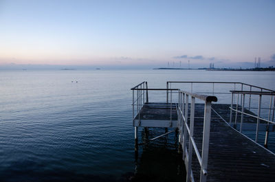 Pier over sea against sky during sunset