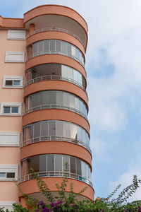 Orange residential building with round balconies against the sky. vertical shot.