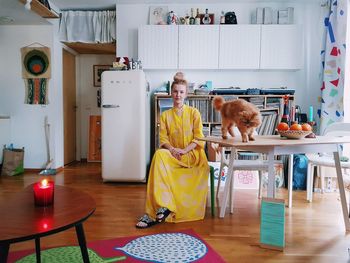 SMILING GIRL STANDING BY TABLE AT HOME