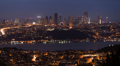 Illuminated buildings in city against sky at night