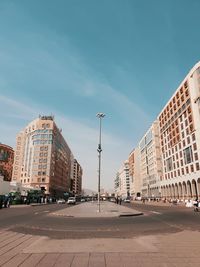 Street amidst buildings against blue sky