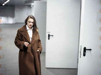 Young woman walking against doors