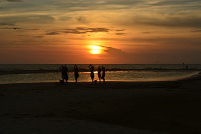 Yogis on beach during sunset