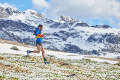 Full length of woman walking on snowcapped mountain