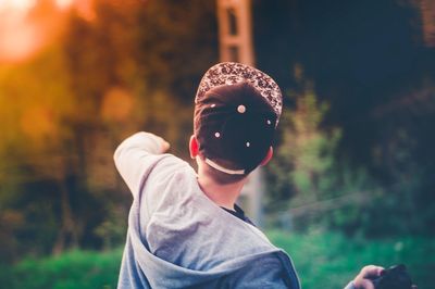 Boy wearing mask against trees