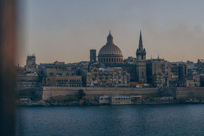 River and buildings against sky