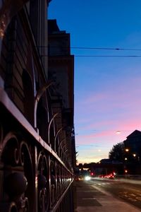 Road in city against sky at sunset