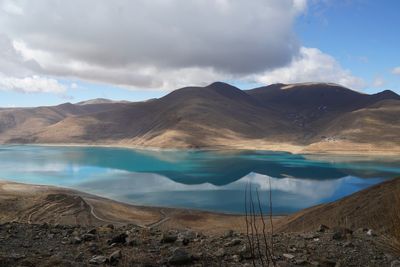 Scenic view of lake by mountains against sky