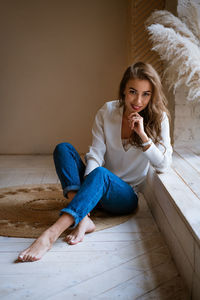 Beautiful happy woman sitting by the window