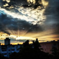 Buildings against cloudy sky at sunset