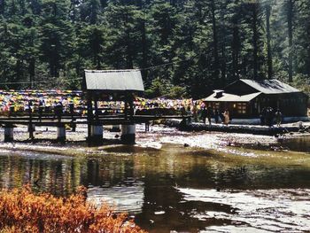 Built structure by lake against trees in forest