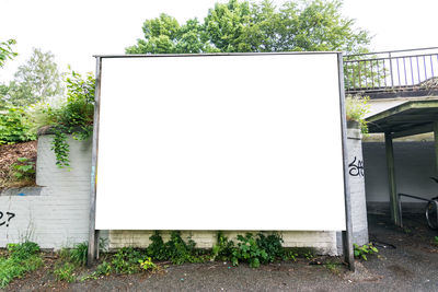 White wall by footpath against clear sky