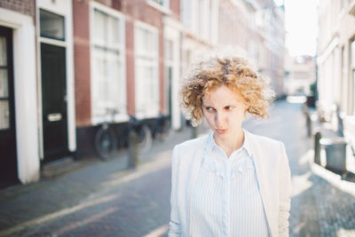 Portrait of young woman standing in city