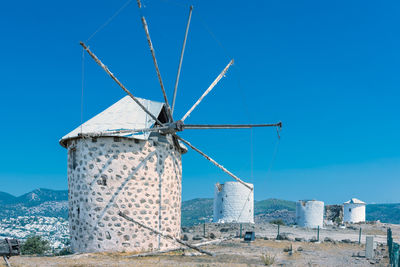 Low angle view of traditional windmill against blue sky