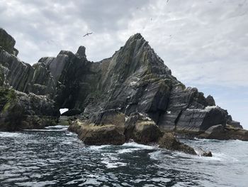 Rock formations by sea against sky