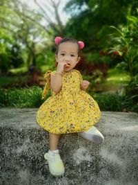 Portrait of cute girl standing on footpath