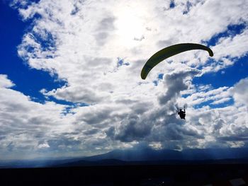 Person paragliding against sky