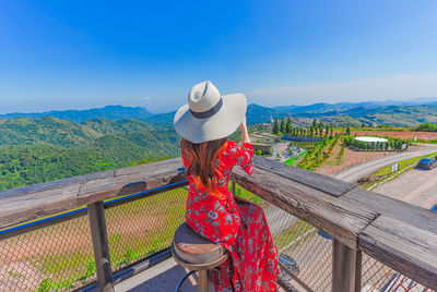 Man looking at view of mountain range against blue sky