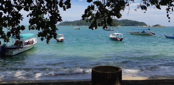 Boats moored on sea against sky