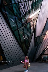 Rear view of woman sitting on glass ceiling