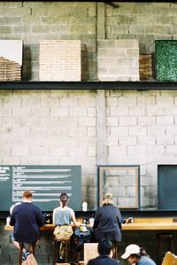 Rear view of people walking in front of building