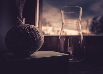 Close-up of drink in glass and pumpkin on table 