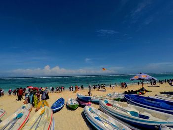 People on beach against blue sky