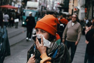 Midsection of man holding smart phone on street