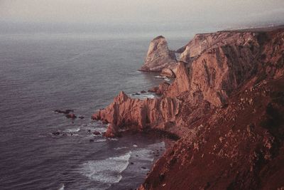 High angle view of rock formation by sea against sky