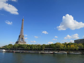 Eiffel tower by seine river against sky