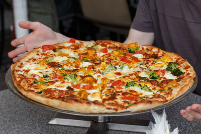 Midsection of man eating pizza