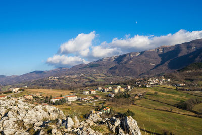 Scenic view of landscape and mountains against blue sky