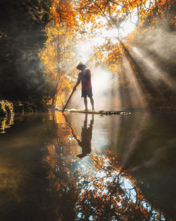 Man standing by lake during autumn