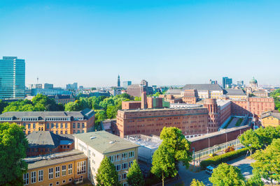 High angle view of buildings against clear blue sky