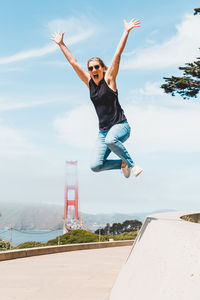 Low angle view of man jumping against sky