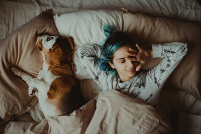 Young woman with dog on bed