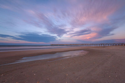 Scenic view of beach against sky during sunset